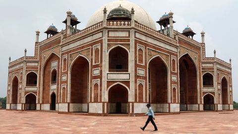 Un guardia camina delante de la tumba de Humayun en la India, que hoy reabre sus puertas tras tres meses de confinamiento