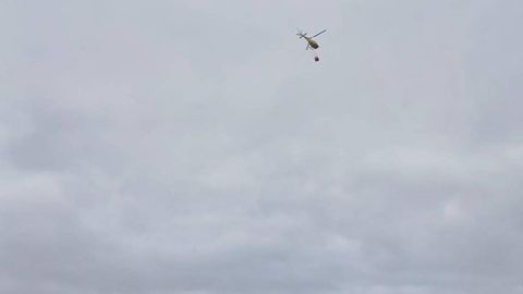 Imagen del helicóptero acudiendo al incendio en Luanco. Foto tomada desde la playa.