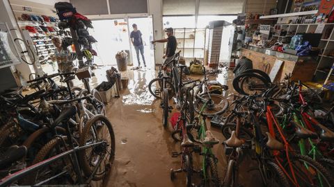  Varias personas evalan los destrozos causados en el interior de su comercio en la localidad valenciana de Catarroja