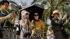 Un grupo de turistas japoneses se protege del fuerte calor que se est registrando estos das en Sevilla