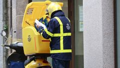Un cartero de Correos entregando correspondencia a domicilio