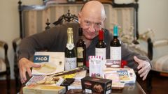 Victoriano Rial de la Fuente posa en su piso de Vigo con las bebidas los dulces y los embutidos que sortea La Voz de Galicia.