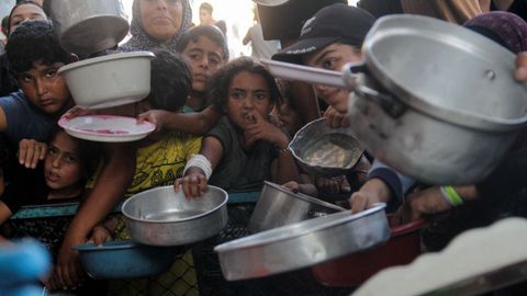 Varios nios gazates, el mircoles esperando para recibir comida de una oeneg.