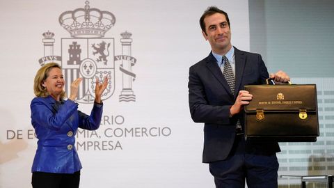 Carlos Cuerpo posa junto a la nueva cartera de Econom�a ante la mirada de Nadia Calvi�o