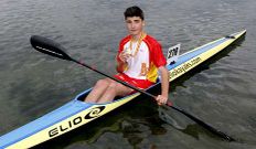 Xoel Garc�a posa coa s�a medalla na piragua coa que competiu. 
