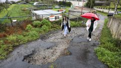 Vecinos de la zona en el camino de As Penas, visiblemente deteriorado y con grandes socavones.