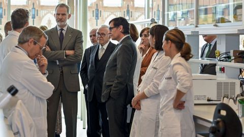 El rey, Felipe VI; el presidente de la Generalitat, Salvador Illa; y el presidente de la Fundaci�n 'la Caixa', Isidro Fain�, escuchan a los profesionales que trabajan en el centro de investigaci�n en inmunolog�a