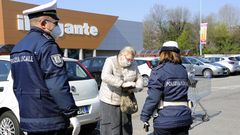 Unos agentes de la polic�a realizan controles a los consumidores en el exterior de un supermercado para verificar si cumplen con la nueva ordenanza municipal sobre compras que, para evitar colas, establece un  orden alfab�tico y durante d�as espec�ficos de la semana en Cesano Boscone, cerca de Mil�n