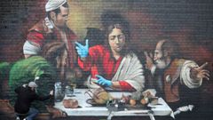 El artista Lionel Stanhope realiza un mural en Ladywell, en Londres, que lleva los guantes protectores a la �Cena de Ema�s� de Caravaggio