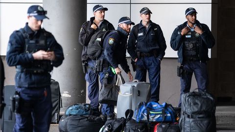 Oficiales de polic�a esperan afuera del aeropuerto, antes de ser transportados a diferentes partes de la frontera entre Nueva Gales del Sur y Victoria, Australia