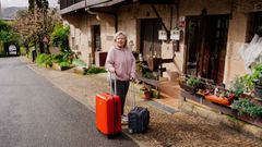 Alicia, con las maletas, frente a la casa en la que vive actualmente