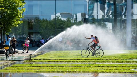 Un hombre en bicicleta se refresca con el agua de unos aspersores en Berln, Alemania. Las temperaturas llegarn a los 40 grados centgrados esta semana segn las previsiones meteorolgicas.