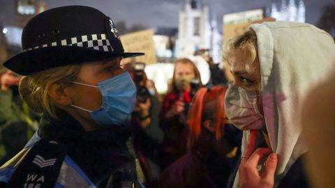 Una manifestante se enfrenta a un policia durante la vigilia de la noche del sbado