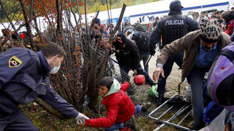 Un grupo de refugiados tratan de romper un cordn policial en  Sentilj, en la frontera de Eslovenia con Austria
