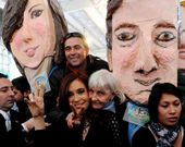 La presidenta argentina se deja fotografiar ante dos cabezudos de ella y de su esposo.
