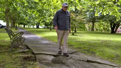Un vecino de Caranza, mayor y con bast�n, pasea por los caminos de cemento del parque.