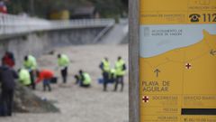 Operarios de Tragsa recogenpletsde plstico en la playa de Aguilar