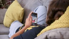 Una adolescente consulta una red social en su m�vil.
