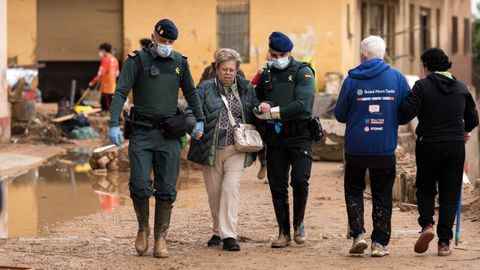 Efectivos de la Guardia Civil ayudan a una mujer en Paiporta