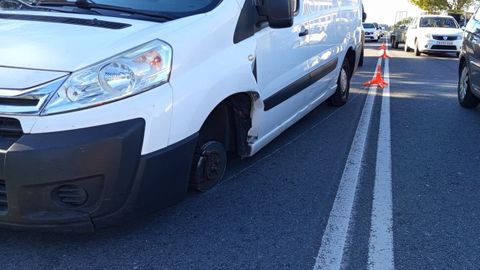Furgoneta sin una de las ruedas delanteras.