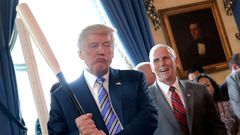 Trump sostiene un bate de b�isbol mientras asisten a un acto para promover productos �made in America� en la Casa Blanca en julio del 2017