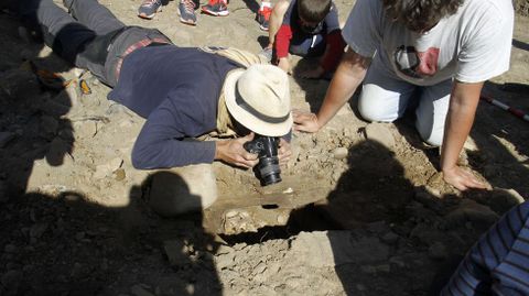 Un arqueólogo saca fotos del interior de la tumba número 53, en la que apareció esta mañana un esqueleto en muy buen estado de conservación