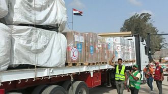 Miembros y voluntarios de la Media Luna Roja Egipcia se reúnen junto a un camión que transporta ayuda humanitaria a Gaza a través del cruce de Rafah.