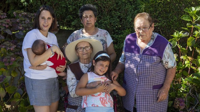 Carmen Garc�a, protegida con un sombrero, con las otras cuatro generaciones de su familia.