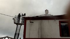 Bomberos tratan de sofocar un incendio en Puerto de Vega (Navia)