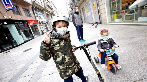 Dos nios con mascarilla por las calles de Vigo