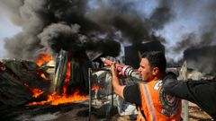 Un bombero palestino intenta sofocr el incendio en una f�brica en la que impacto un misil israel�