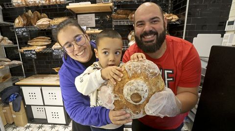 Nati Cancela y Dani Pamp�n con su hijo peque�o en su panader�a, al que llevaron al trabajo por no haber tener guarder�a esa jornada.