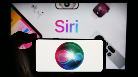 Un usuario sostiene un�m�vil con el logo del asistente digital de Siri