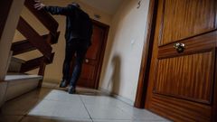 Un hombre, frente a la puerta de la vivienda del fallecido