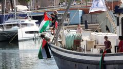 Activistas cuelgan banderas palestinas en uno de los barcos de la Global Sumud Flotilla.