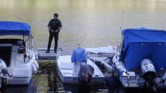 Un guardia civil junto al cuerpo del chico fallecido, tapado con una s�bana en el embarcadero pr�ximo a la presa de Os Peares