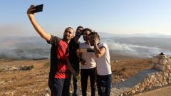 Varios j�venes se hacen un selfi 
La gente se toma selfies en el lugar donde cayeron proyectiles disparados desde Israel en la aldea Maroun al Ras