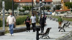Gente con mascarilla paseando por el paseo de Coroso en Ribeira