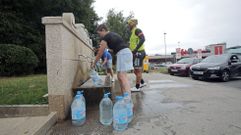 Vecinos recogiendo agua en la fuente de Fontoira, en Sanxenxo