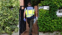 Un agente de la Polic�a Nacional entra en la vivienda de la mujer asesinada en Valladolid