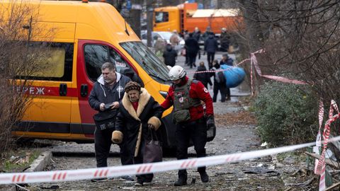 Unos sanitarios evacuan a una mujer tras un ataque con drones rusos contra un edificio de apartamentos.