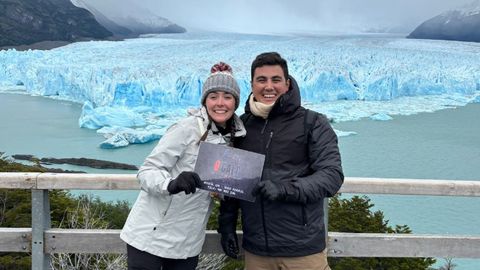 Carmen y su pareja, con el cartel promocional de O'Galo en el glaciar Perito Moreno de Argentina