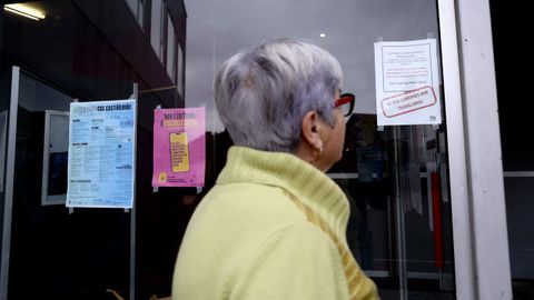 Una usuaria de los centros socioculturales mira los carteles en los que los trabajadores dan cuenta de su situaci�n