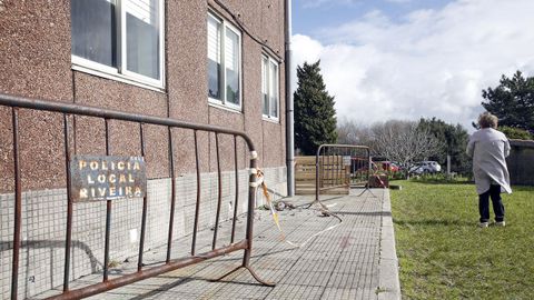 Dos vallas impiden acceder a la zona donde se han desprendido los cascotes en el colegio de Olveira