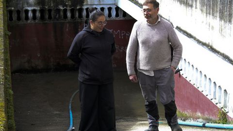 Aguas fecales en la calle Noria de Cangas con  una vecina y el encargado de la empresa San Vicente que se dedica a achicar el garaje