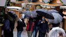  Varias personas se protegen de la lluvia con paraguas en el centro de Oviedo