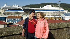 Dos cruceristas tom�ndose una foto en Ferrol con el buque de fondo
