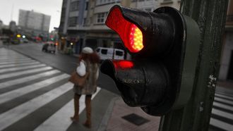 Imagen de archivo de una persona cruzando en un paso de peatones regulado por un sem�foro