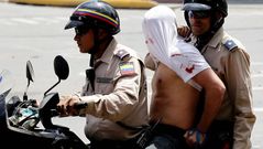 La polic�a se lleva en una motocicleta a un detenido