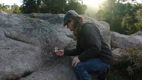 El arqueólogo Antón Fernández Malde, ante el relieve femenino de la Moura, en el santuario de Pena Furada, en el municipio de Coirós.